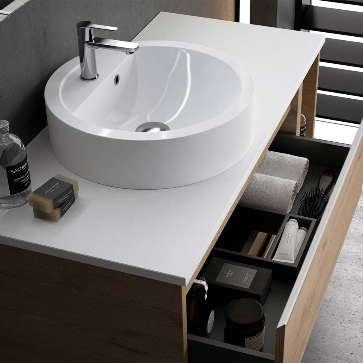 muebles-auxiliares-de-bano Modern bathroom vanity with a round white vessel sink and chrome faucet; open drawer shows towels and grooming items inside.