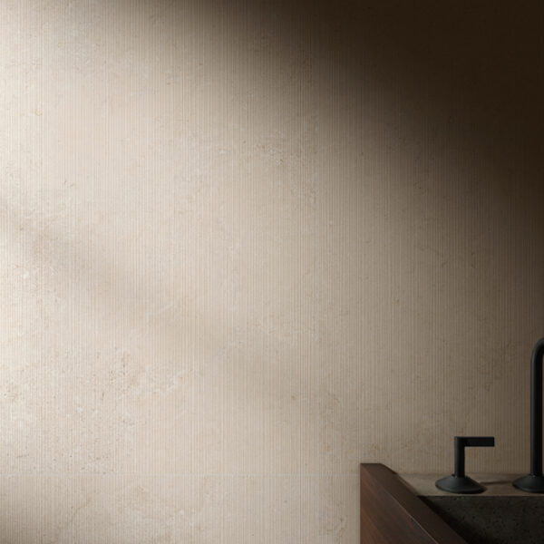 Beige textured wall with a dark modern faucet visible at the sink in the lower right corner.