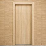 Interior wooden door with horizontal panel sections, framed by a light wood trim against a matching paneled wall.