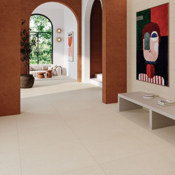 Interior hallway with arched doorways, terracotta columns, and a large abstract painting on the wall; neutral seating area in the background.