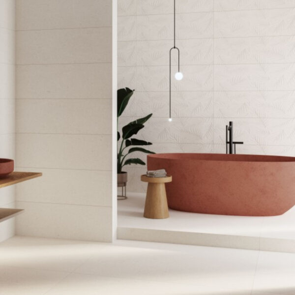 Modern bathroom with a terracotta freestanding bathtub, white textured tile wall, black faucet, and a potted plant.