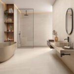 Spa-like modern bathroom with a freestanding oval tub, glass-walled shower, and floating vanity with a round vessel sink and oval mirror.