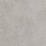 Close-up of a light gray concrete surface with tiny embedded pebbles and subtle staining.
