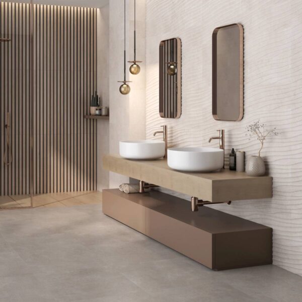 Modern bathroom with two round white vessel sinks on a floating beige vanity, bronze taps, and wavy textured wall